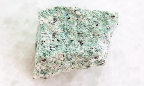 macro shooting of natural mineral rock specimen - raw Trachyte stone on white marble background