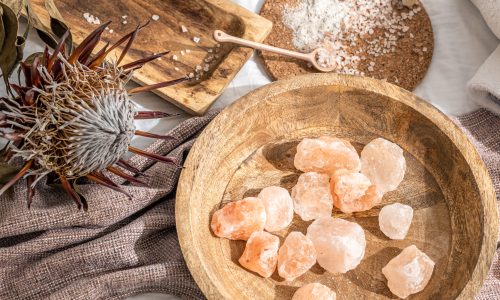 Spa composition with pieces of sea salt in a wooden plate, health and beauty concept.